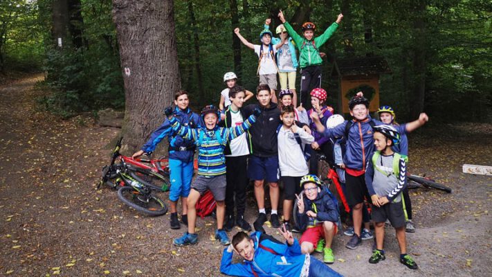 Gruppenfoto: Schüler und Schülerinnen auf der Tour durch den Wald mit ihren Mountainbikes