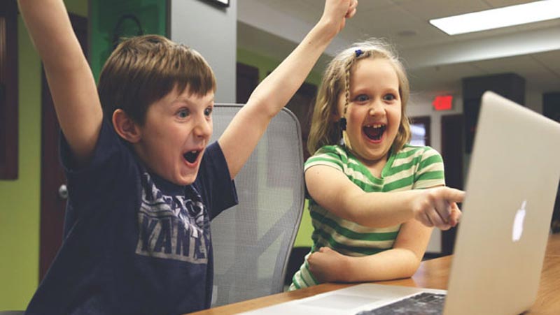 move&meet Onlineunterricht. 2 Kinder sitzen animiert vor dem Laptop