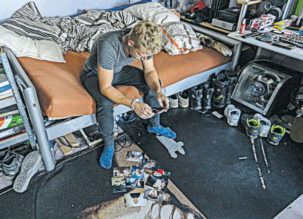 Philipp sitzt auf seinem Bett und betrachtet Fotos aus seiner Kindheit